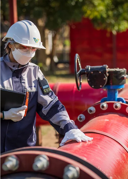 Trabajador con equipo de seguridad operando válvula industrial