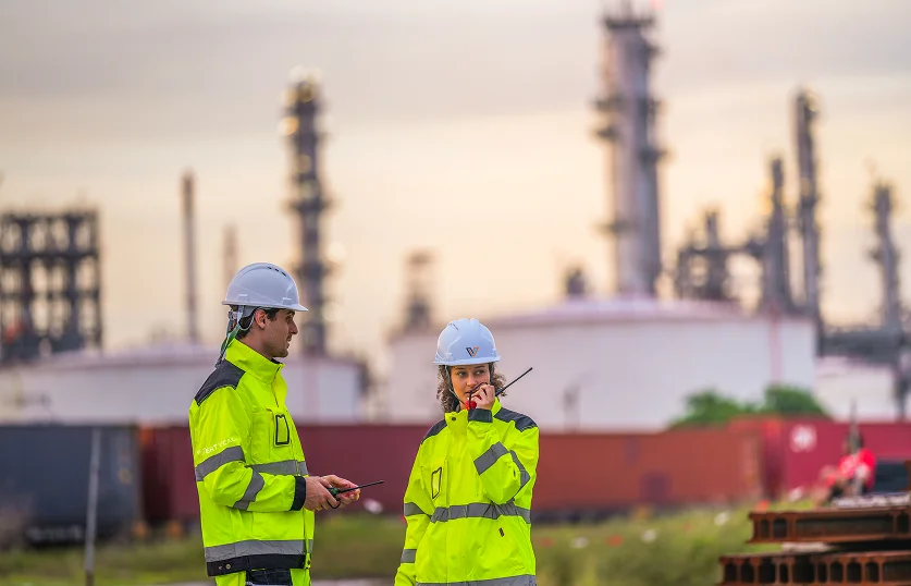 Profesionales con ropa de alta visibilidad en planta industrial